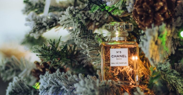 Elegant Chanel No. 5 perfume bottle hanging on a festive Christmas tree.